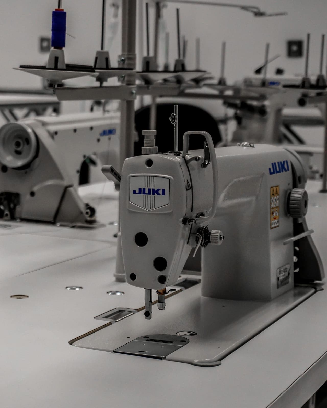 Industrial sewing machine on a clean production bench, set up for precision stitching