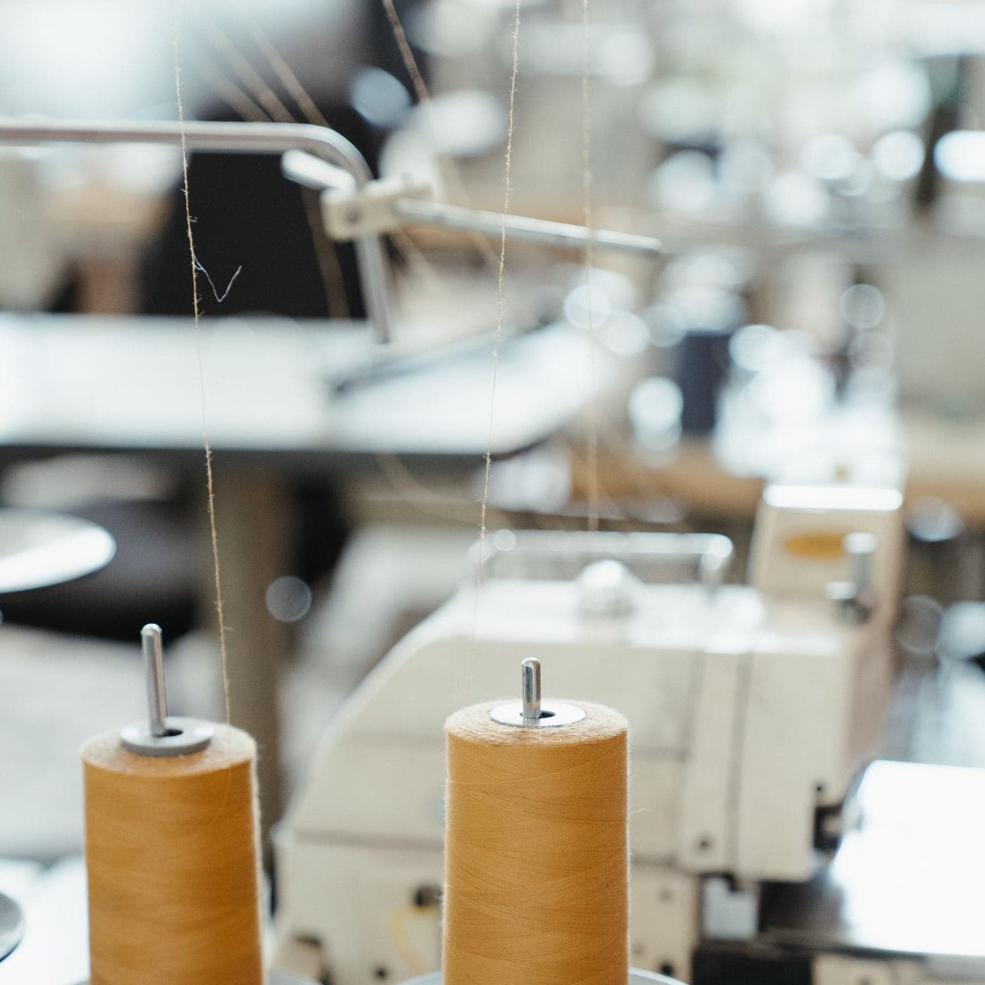Close-up of thread cones mounted on an industrial sewing machine