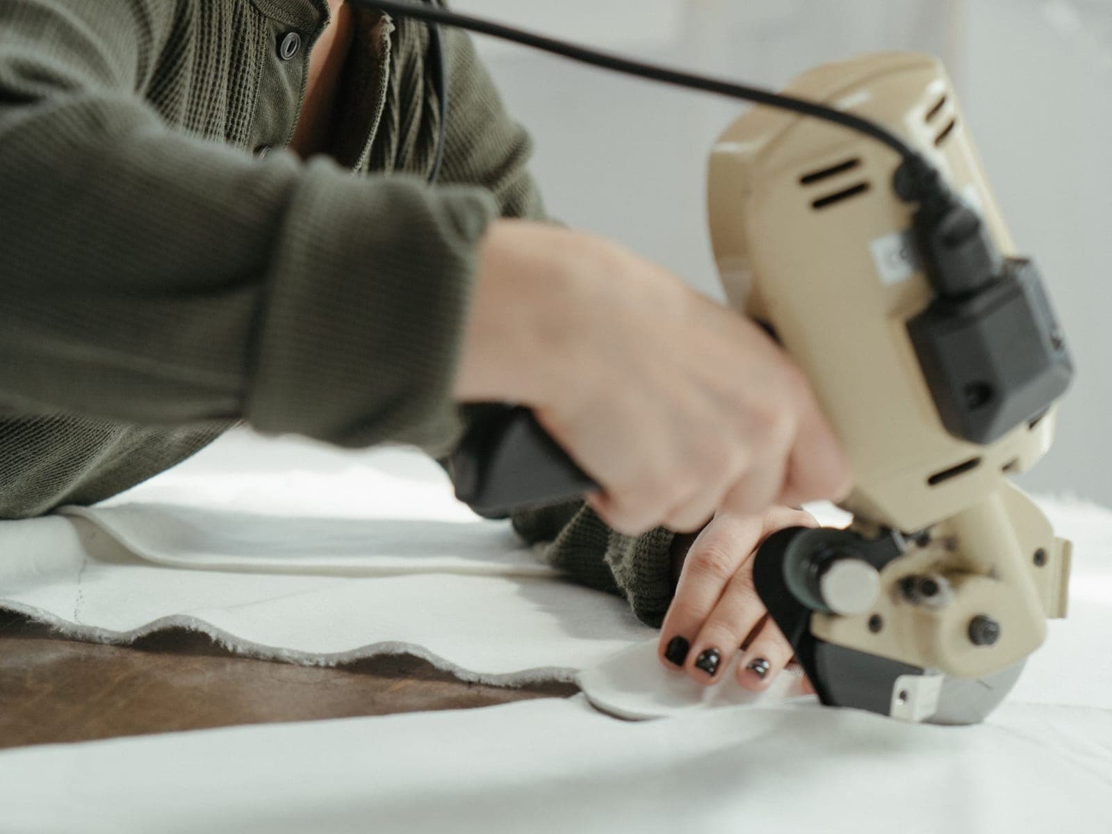Fabric being cut by hand in a sampling room