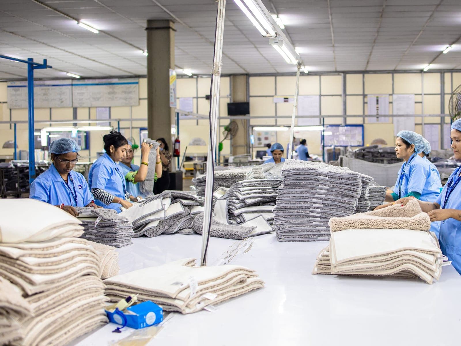 Finished garments being folded and sorted into stacks for packing