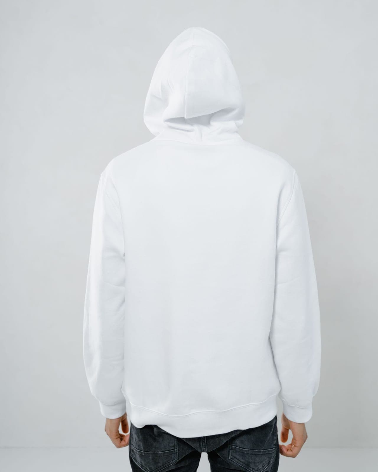 Plain white pullover hoodie photographed from behind, showing the hood and shoulder construction