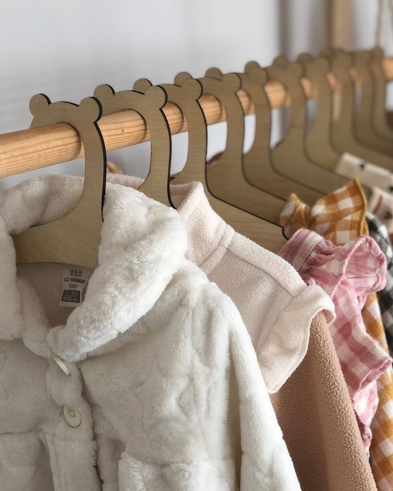 Children's garments hanging in a row on small wooden hangers