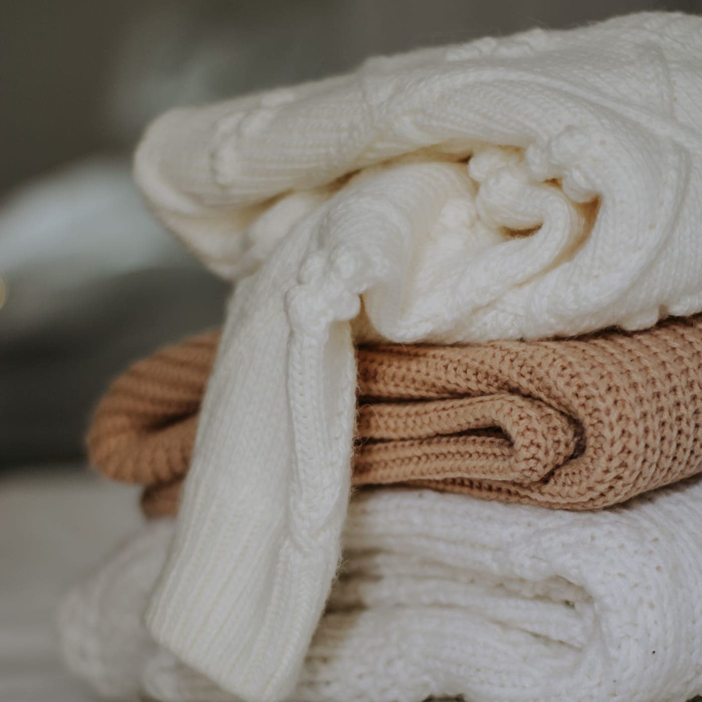 Soft cream knitted garments folded to show the smooth, lightweight jersey face