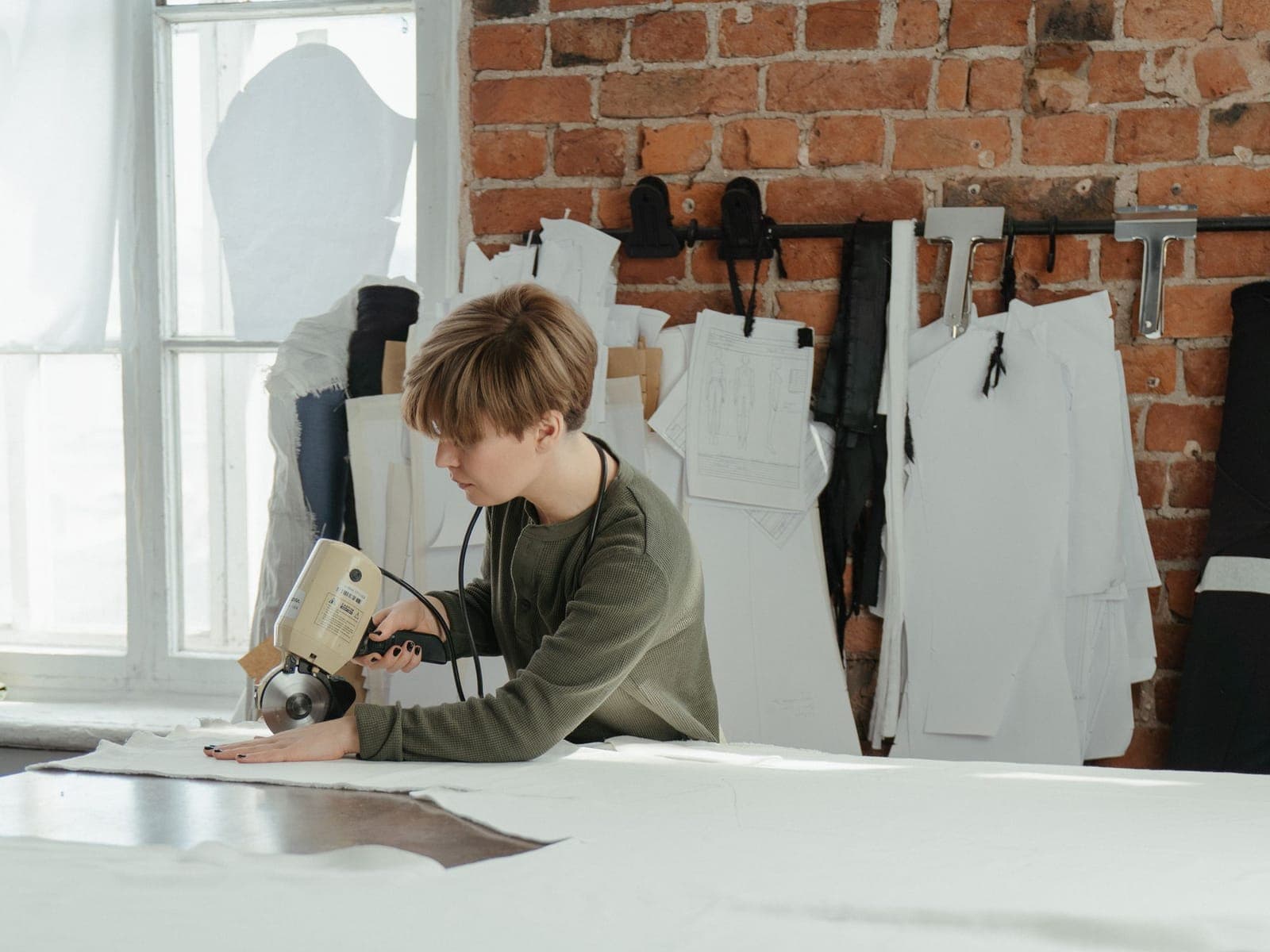 Paper garment patterns and cut fabric pieces laid out on a cutting table